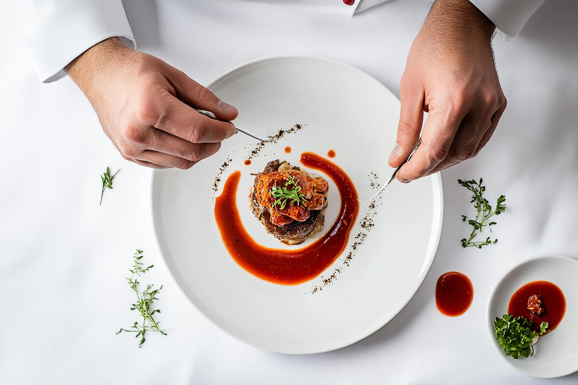 Chef preparing plated dish in calm studio
